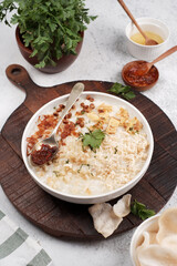 Bubur ayam is Indonesian chicken porridge, made of rice porridge topped with shredded chicken, fried shallots, scallions, crackers, and soy sauce.