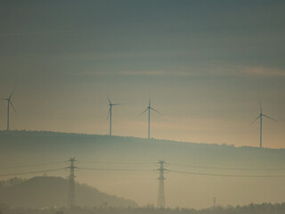 Strommasten und Windr&auml;der im Nebel in der Ferne