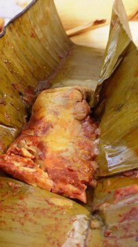 Probar tamal envuelto en hoja de pl&aacute;tano con pollo y salsa desayuno mexicano 