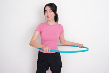 A woman showing happy face when exercise using hula hoop © KrishnaTedjo