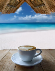 photo d'une tasse de café coeur de lait dans la mousse à la plage mer tropicale