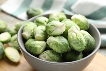 Fresh green Brussels sprouts in bowl on table, closeup