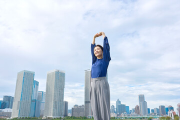 外で伸びをする女性