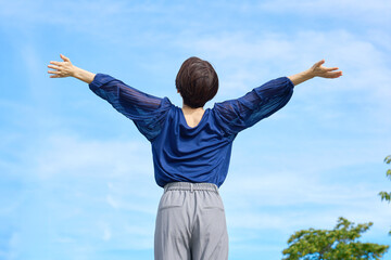 外で深呼吸する女性　後ろ姿