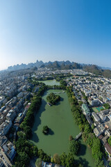 Scenic Aerial View of Urban Landscape Surrounded by Mountains and Greenery