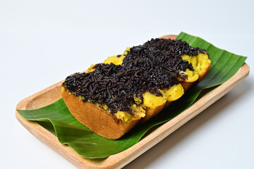Pukis cakes with chocolate sprinkle as toping and banana leaf on the long wooden plate. Isolated on the white background