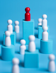Red wooden figure standing on wooden podium for business leadership for team leader concept.