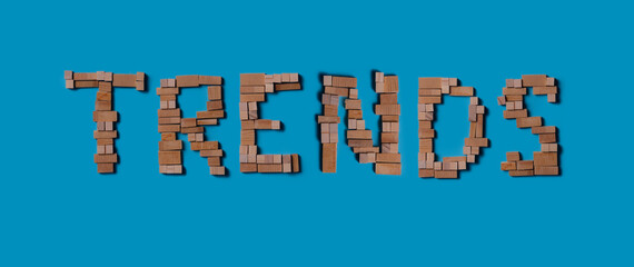 “TRENDS” word made of wooden blocks on blue background, top view
