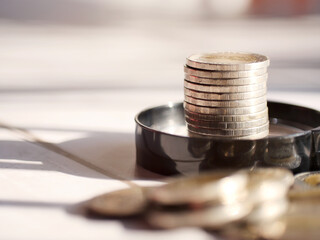Coins with black magnifying glass. Saving money and financial business concept.Copy space.