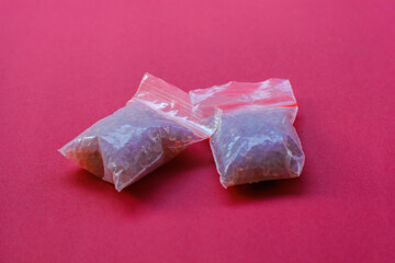 a collection of silica gel wrapped in small plastic on a red background