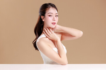 Naklejka premium Elegant Asian woman model with natural makeup on face clean fresh skin on isolated Beige background.