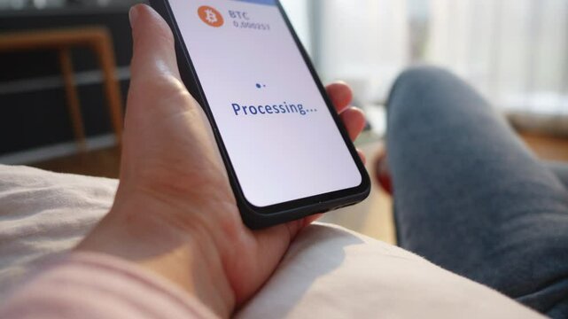 Woman confirming cryptocurrency payment on smartphone. Person hand clicking button on mobile screen while paying with crypto wallet online close up
