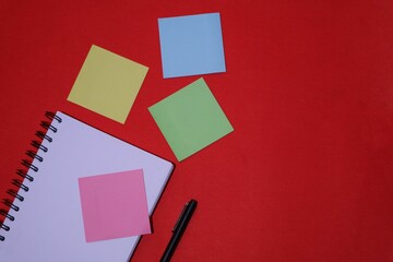 books, pens and colorful memo paper, creative layout, isolated on red background. top view