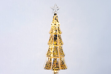 Golden glass Christmas tree on white background.