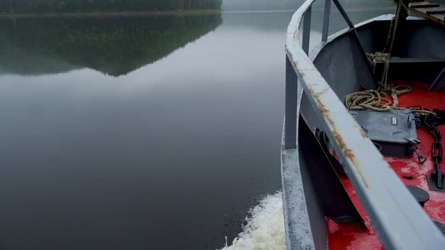 Zeya Reservoir. Picturesque views from a calm lake to green hills and forest. View from a boat. A boat sails along a calm lake.