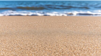 Sandy beach foreground with gentle waves and a clear blue ocean background, creating a serene coastal atmosphere.