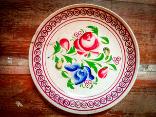 vintage ceramic round platter with floral pattern on a wooden background