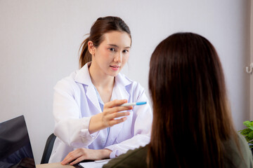 Young asian patient woman consulting with doctor in coat about wrinkle and skin for rejuvenate and beauty while watching laptop in modern medical office, doctor explaining and diagnostic facial.