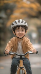 Naklejka premium A cute Asian youngster is enjoying himself while riding a bicycle. .