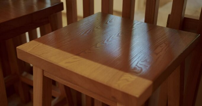 Modern minimalist cafe with wooden chairs and tables with no people on a sunny day. Empty dining table and chairs. Modern wooden furniture in cafe. Close up wooden chair. Eco Friendly Cafe.