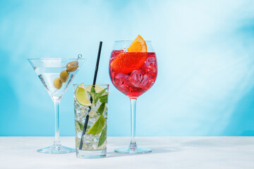 A variety of cocktails arranged on a table against a light blue background