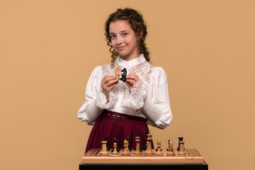 Young girl displaying black and white chess knights © Vagengeim