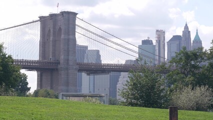 Brooklyn Bridge, New York City Manhattan downtown skyline architecture, financial district cityscape, United States. Dumbo park grass, green picnic lawn near waterfront carousel, USA.