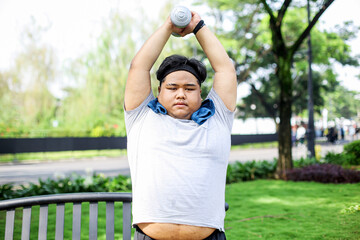 Fat Man Raised Hands While Holding Up Dumbbell. Workout on Park