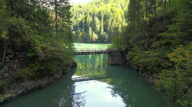 Picturesque bridge on the alpine lake called Scropoasa , Bucegi Natural Park , Carpathian Mountains, Romania, aerial view.