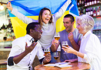 Happy fans celebrating the victory of Ukrainian team in the bar