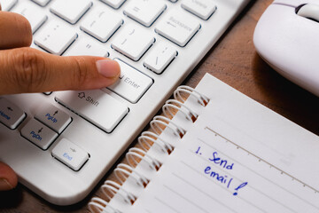 finger pressing enter key on a laptop keyboard at the office, sending email concept