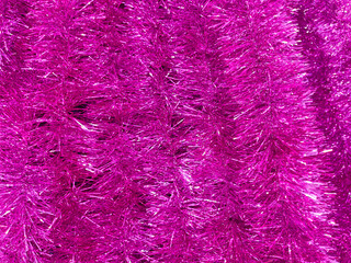 Pink Christmas tinsel as a background. Texture. Close-up.