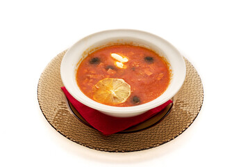 A bowl of soup with a slice of lemon on top
