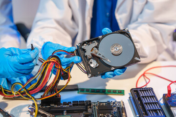 Naklejka premium Close-up of a technician wearing gloves soldering electronic components at a desk in an office. The scene highlights precision, technical expertise, and focused work in an electronics lab setting