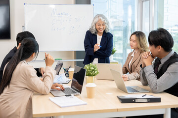 Executives are having a meeting with employees to discuss business planning in a conference room.