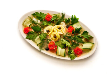 A white plate with a variety of vegetables including cucumbers, tomatoes