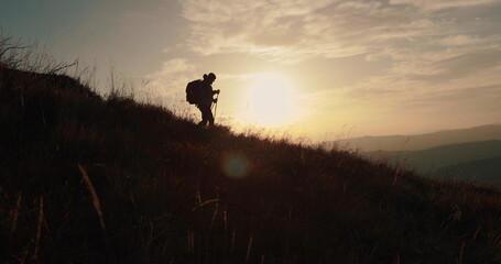 Silhouette of a traveler descending a mountain against a stunning backdrop. Atmospheric shots with...