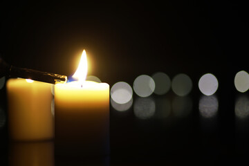 Candle Being Lit in Dark Room with Bokeh Light Background