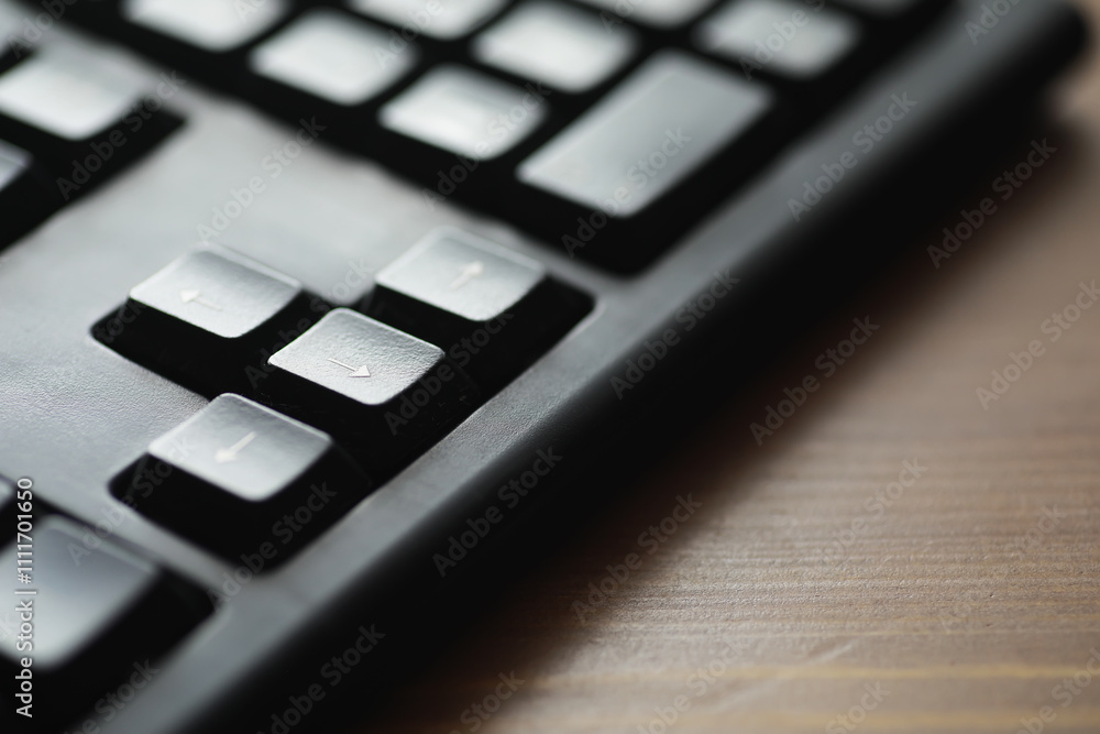 Aufkleber close-up of black computer keyboard on wooden surface with focus on arrow keys