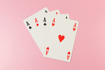 Top view of playing cards on pink background. Four aces cards, board game, poker. Copy space, flat lay.