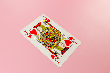 Top view of playing cards on pink background. One jack card, board game, poker. Copy space, flat lay.