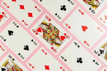Top view of playing cards on pink background. Lot of cards, board game, poker. Copy space, flat lay.