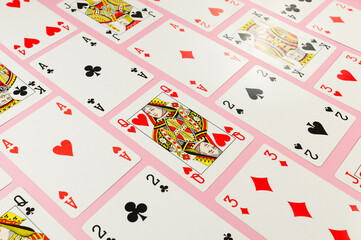 Top view of playing cards on pink background. Lot of cards, board game, poker. Copy space, flat lay.