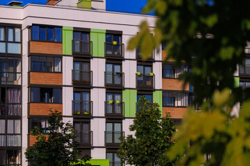 Cityscape on a summer day, modern buildings and houses against the blue sky 
