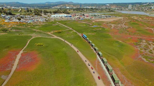 Aerial panoramic of cargo train off road in Chilean countryside Valparaiso landscape Ritoque City