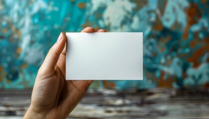 A hand holding a white card with no writing on it