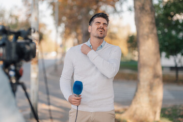 Stressed reporter feeling uncomfortable during live broadcasting in city park