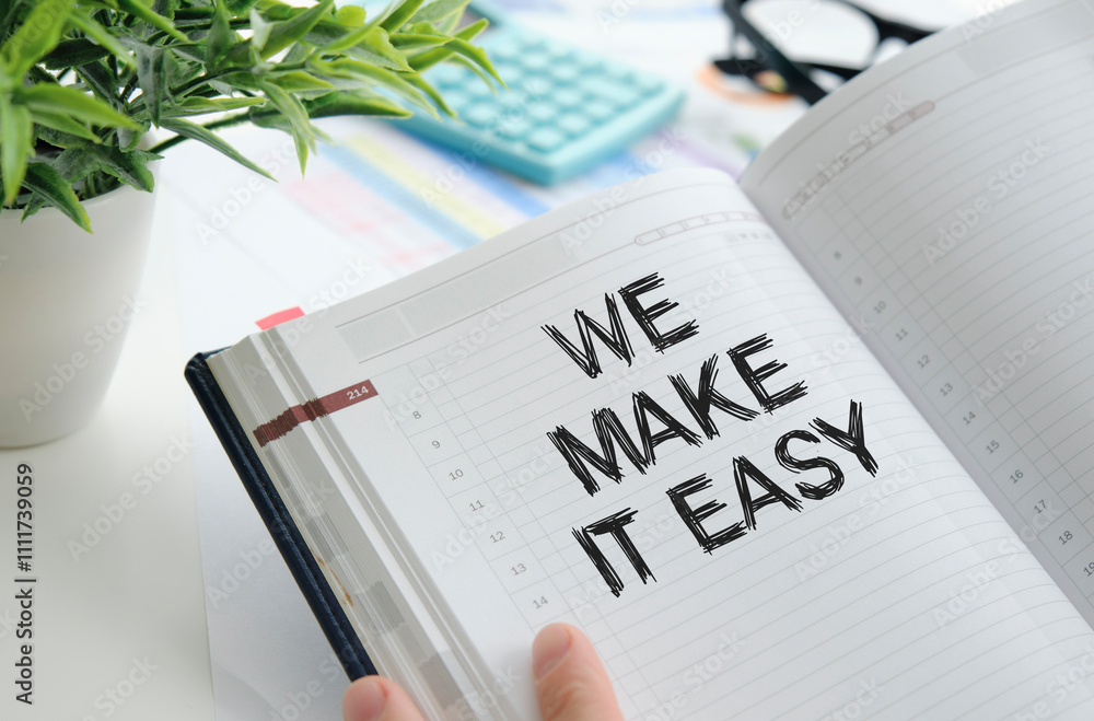 Poster we make it easy text on white notepad paper in hand on white background