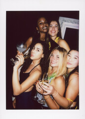A vintage-style instant camera photo of friends enjoying a lively party, holding drinks and...