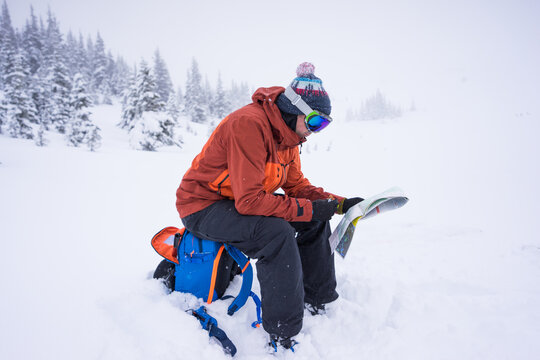 Backcountry skier checks map to navigate during whiteout conditions.